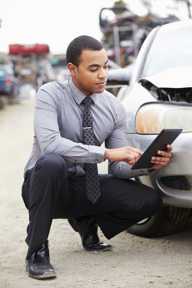 Insurance adjuster inspecting the damages in a car accident in Bronx.