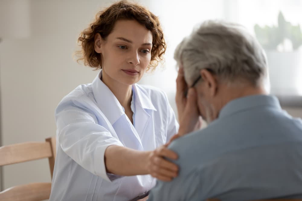 A young woman comforting depressed and unhealthy patient.