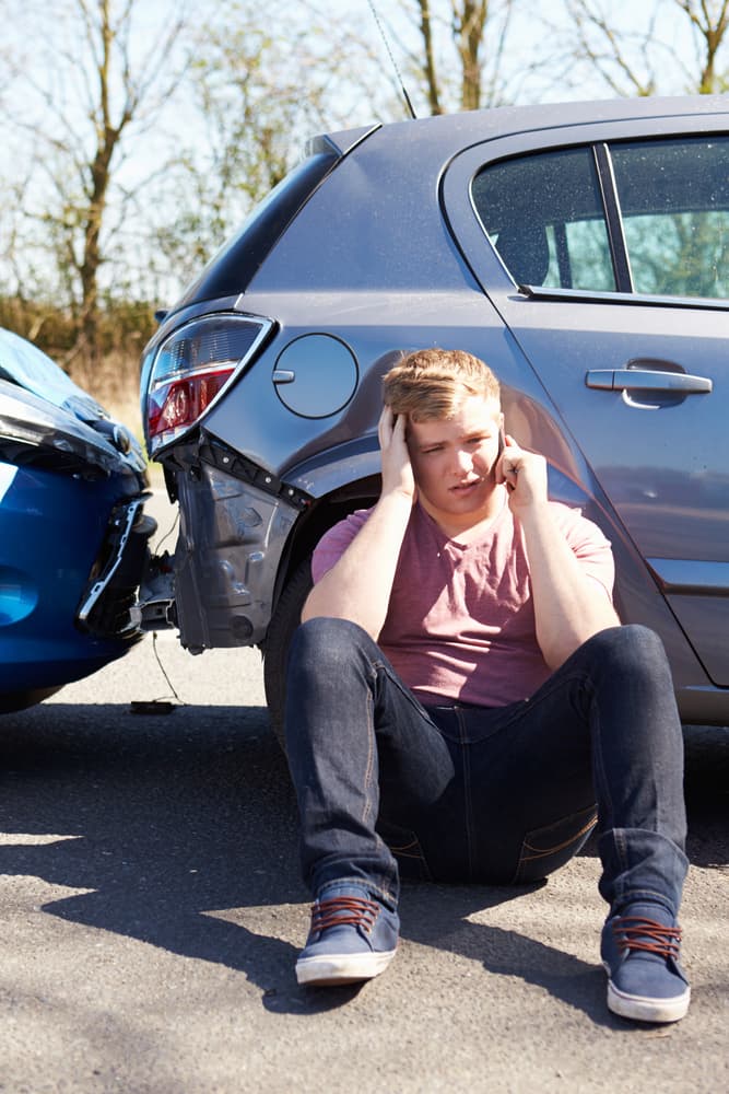 Driver using phone after traffic accident.