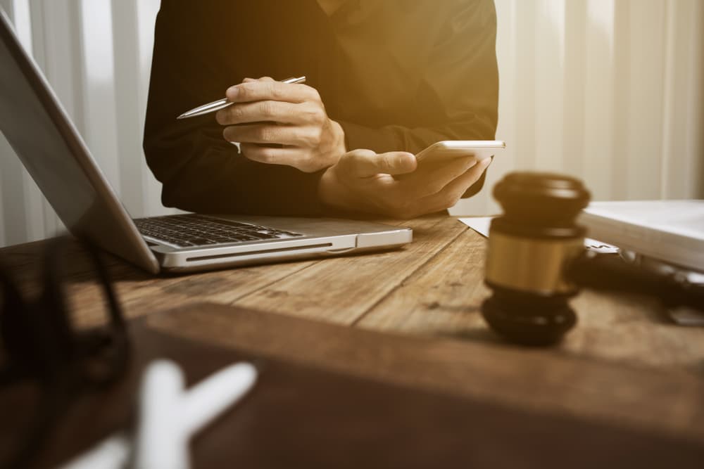 Young lawyer working hard for the fair settlement in his California office.